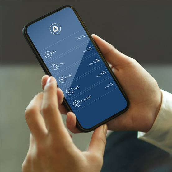 A person is holding a smartphone that displays a financial app with a list of cryptocurrencies including BTC, ETH, USDC, EURC, and Paxox Gold, each with a different annual percentage yield.